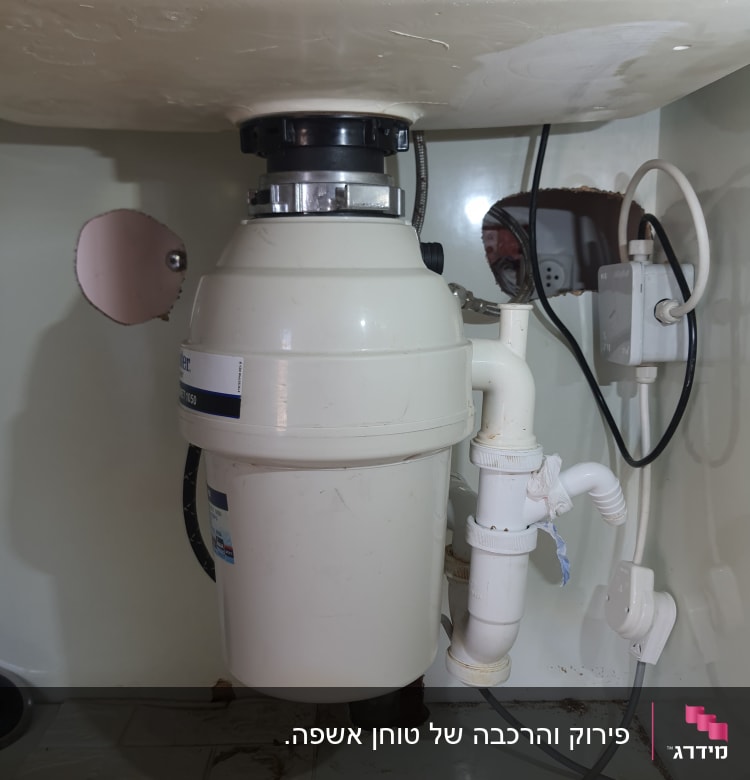 מתקן טוחן אשפה מתחת לכיור עם צינורות חיבור